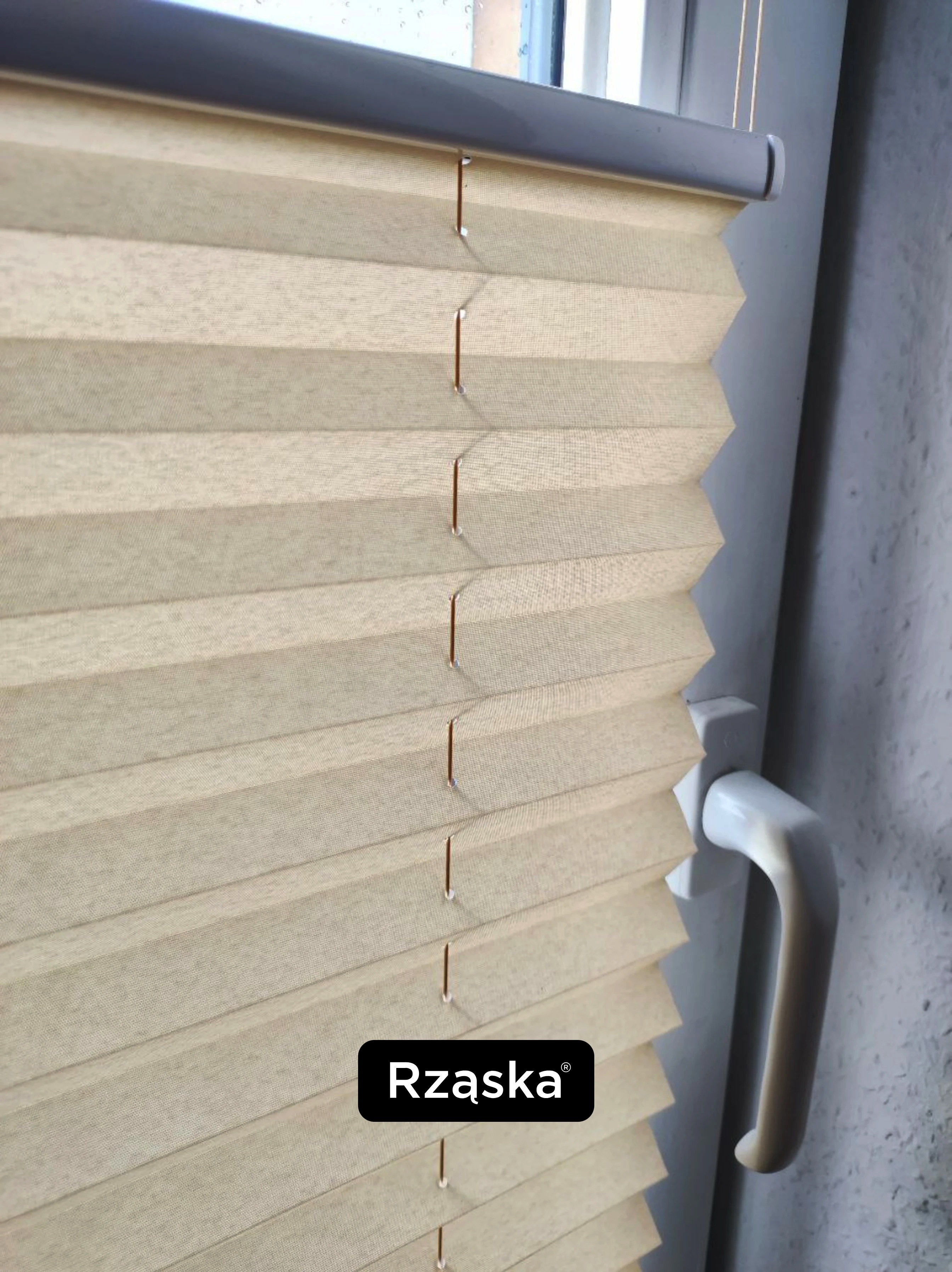 Plisa okienna na oknie z klamką